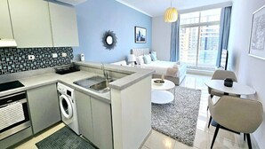 A compact living space with a kitchenette, a dining area, and a bedroom.