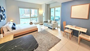 Une chambre d’hôtel moderne équipée d’un lit, d’un canapé, d’une table à manger et de chaises.