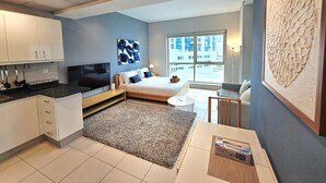 Un appartement moderne comprenant une cuisine, une chambre avec une grande fenêtre et un espace de vie.