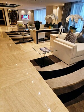A modern hotel lobby with a marble floor, a reception desk, a sofa, and a coffee table. - Sunrise Homes - Chic Studio close to Dubai Mall with Canal Views (Business Bay)