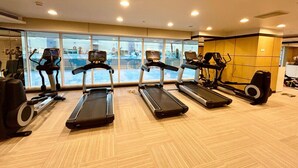 A gym with treadmills, elliptical machines, and a rowing machine.