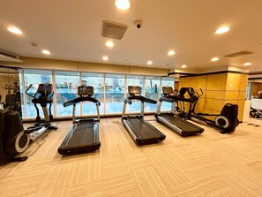 A gym with treadmills, elliptical machines, and a rowing machine.
