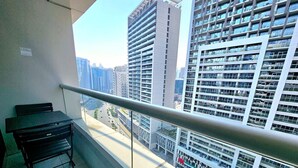 A balcony with a metal railing, a black table, and a black chair.