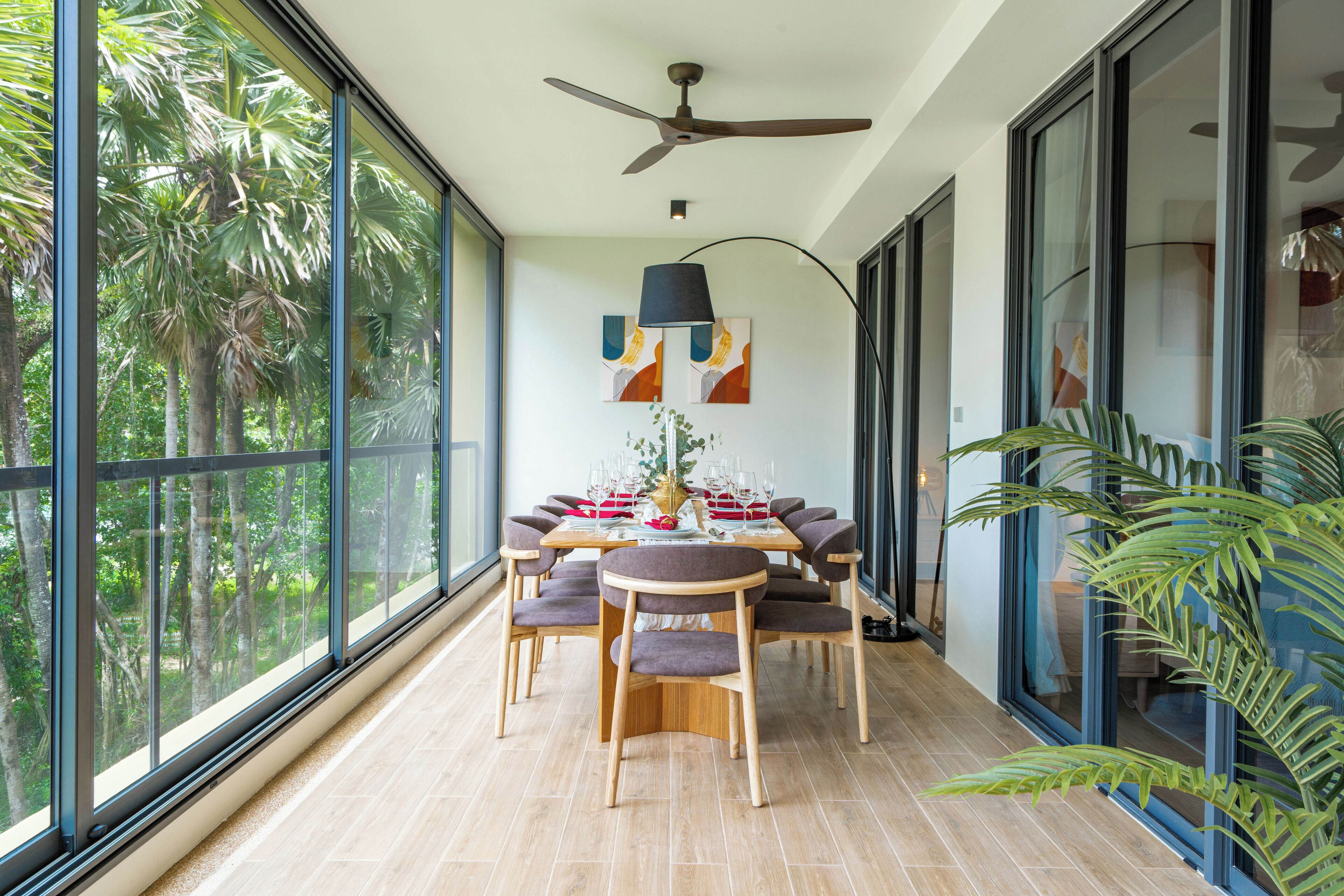 A dining area with a large window, a ceiling fan, and a table set for dining.