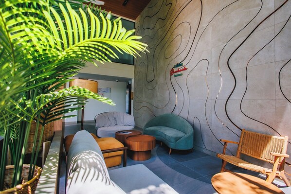 A modern lounge area with a sofa, armchairs, and a coffee table.