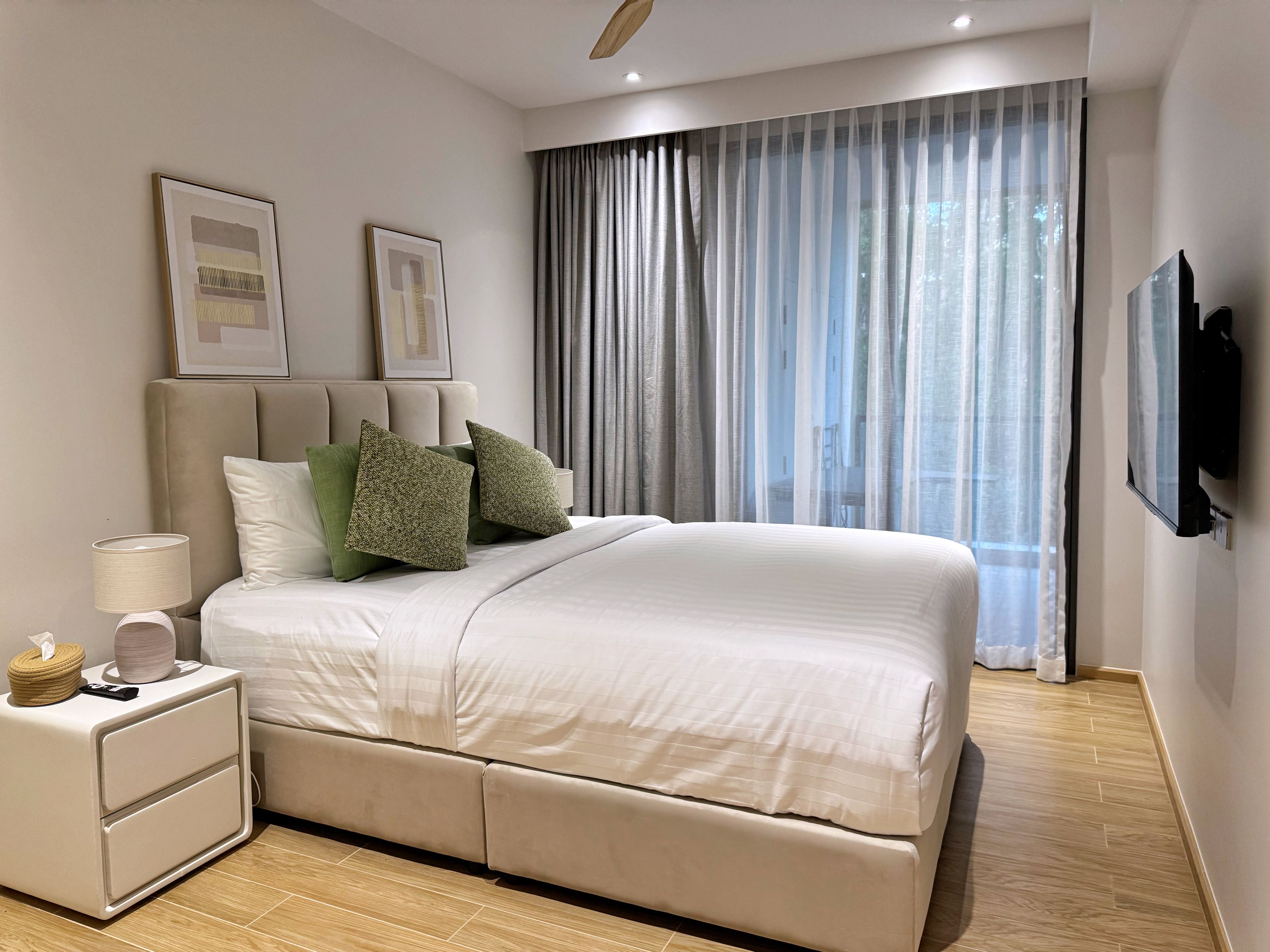Ein modernes Schlafzimmer mit Bett, Nachttisch, Lampe und Kunstwerk an der Wand.