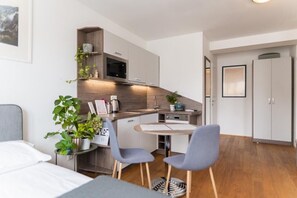 Quarto quádruplo luxo, sacada | Área de estar | Smart TV 60 cm com canais a cabo, pisos aquecidos, impressoras