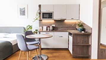 Habitación cuádruple Deluxe, balcón | Cocina privada | Frigobar, microondas, parrilla de estufa y cafetera y tetera