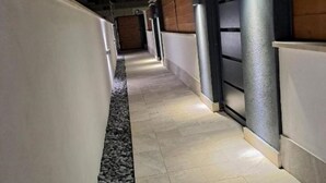 A narrow corridor with tiled flooring, a pebble border, and walls with a combination of white and dark panels. - Sirene452 - where to combine the relaxation of the sea and the proximity to the eternal city (Torvaianica)
