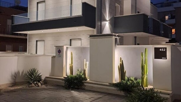 A modern multi-story building with a flat roof, large windows, and a well-lit entrance. - Sirene452 - where to combine the relaxation of the sea and the proximity to the eternal city (Torvaianica)