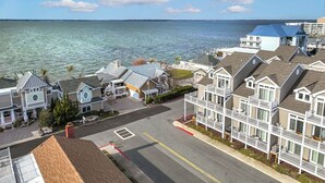 A coastal residential area with houses featuring balconies and a view of the sea. - Welcome to your dream bay-view townhouse, where relaxation meets excitement. Sleep 12 guests. Linens included. Vacation at the shore with Shoreline Properties (Ocean City)