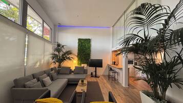 Superior appartement, uitzicht op tuin | Woonruimte | Een flatscreentelevisie en een computerscherm