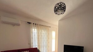 A modern living room with a sectional sofa, a flat-screen TV, and a coffee table. - Albania Dream Holidays Apartment (Sarandë)
