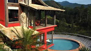 A house with a pool, surrounded by lush greenery and hills. - Pousada Mauá Brasil (Resende)