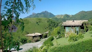 A rural landscape with traditional houses, a clear sky, and rolling hills in the background. - Pousada Mauá Brasil (Resende)