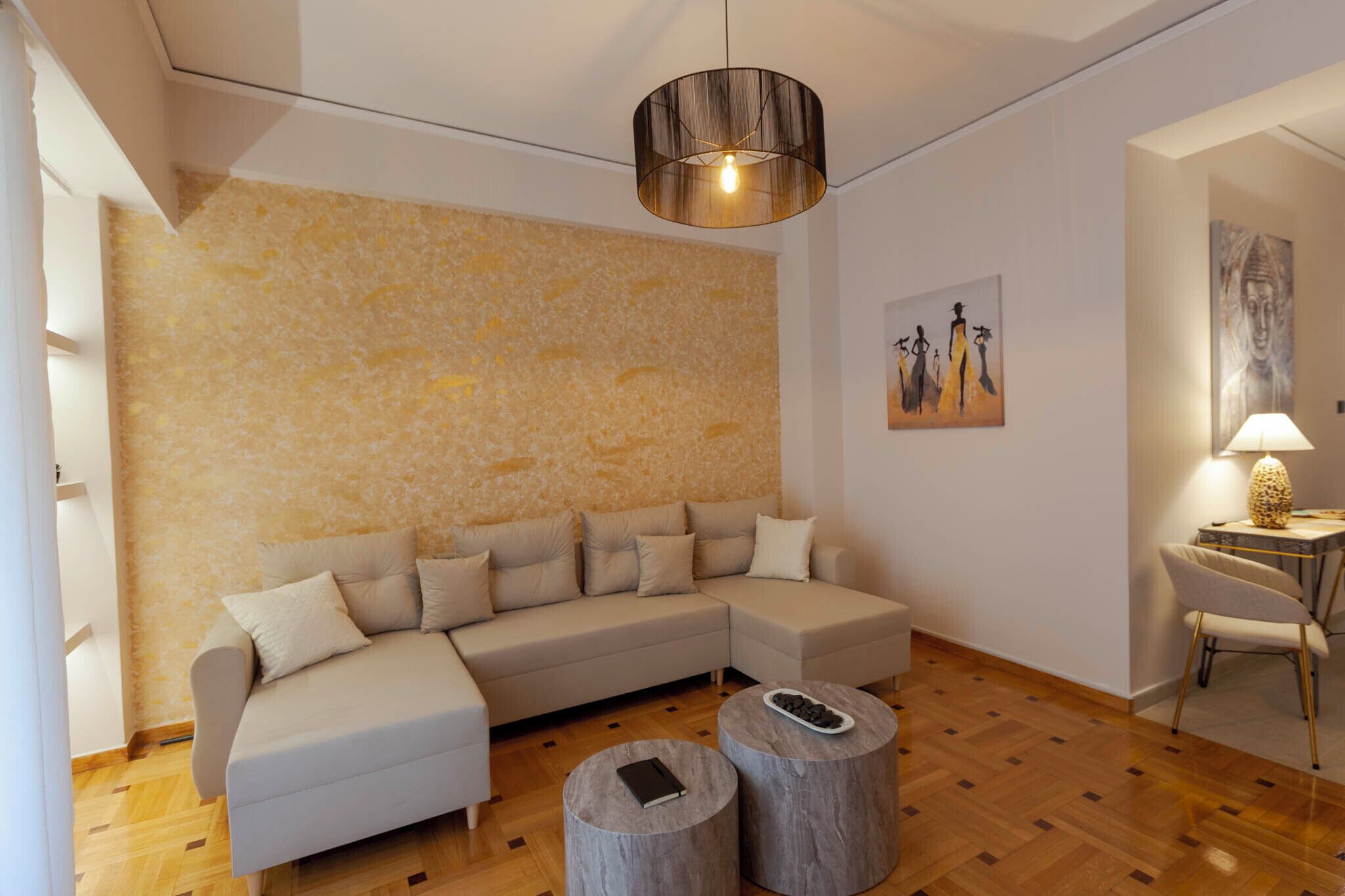 A modern living room with a sectional sofa, round coffee tables, and artwork on the walls.