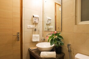 A bathroom with a sink, towel rack, hair dryer, and a potted plant. - Alaya Stays Veera Strand Park 2BHK Apts (Calangute)