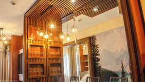 Quarto com painéis de madeira, televisão montada e um mural com paisagem de montanhas.
