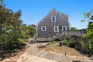 A wooden house with a porch, a wooden deck, and a fenced yard. - Walk to Oceanside Beach! (Wellfleet)
