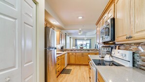 A modern kitchen with wooden cabinets, stainless steel appliances, and a large island. - 5 Mi to Jetblue Park: Condo w/ Pool & Pickleball (Fort Myers)