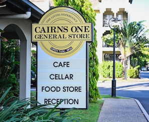 A sign for Cairns One General Store listing its amenities: cafe, cellar, food store, and reception. - Palm View- 9 Pools BBQ Gym (Westcourt)