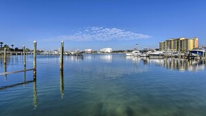 A marina with boats docked, a wooden walkway, and a large hotel in the background. - Walk to Beach: Resort Retreat w/ Balcony in Destin (Destin)
