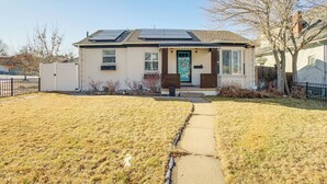 Einbungalow mit Vorgarten, einem Weg zum Eingang und Solaranlage auf dem Dach.