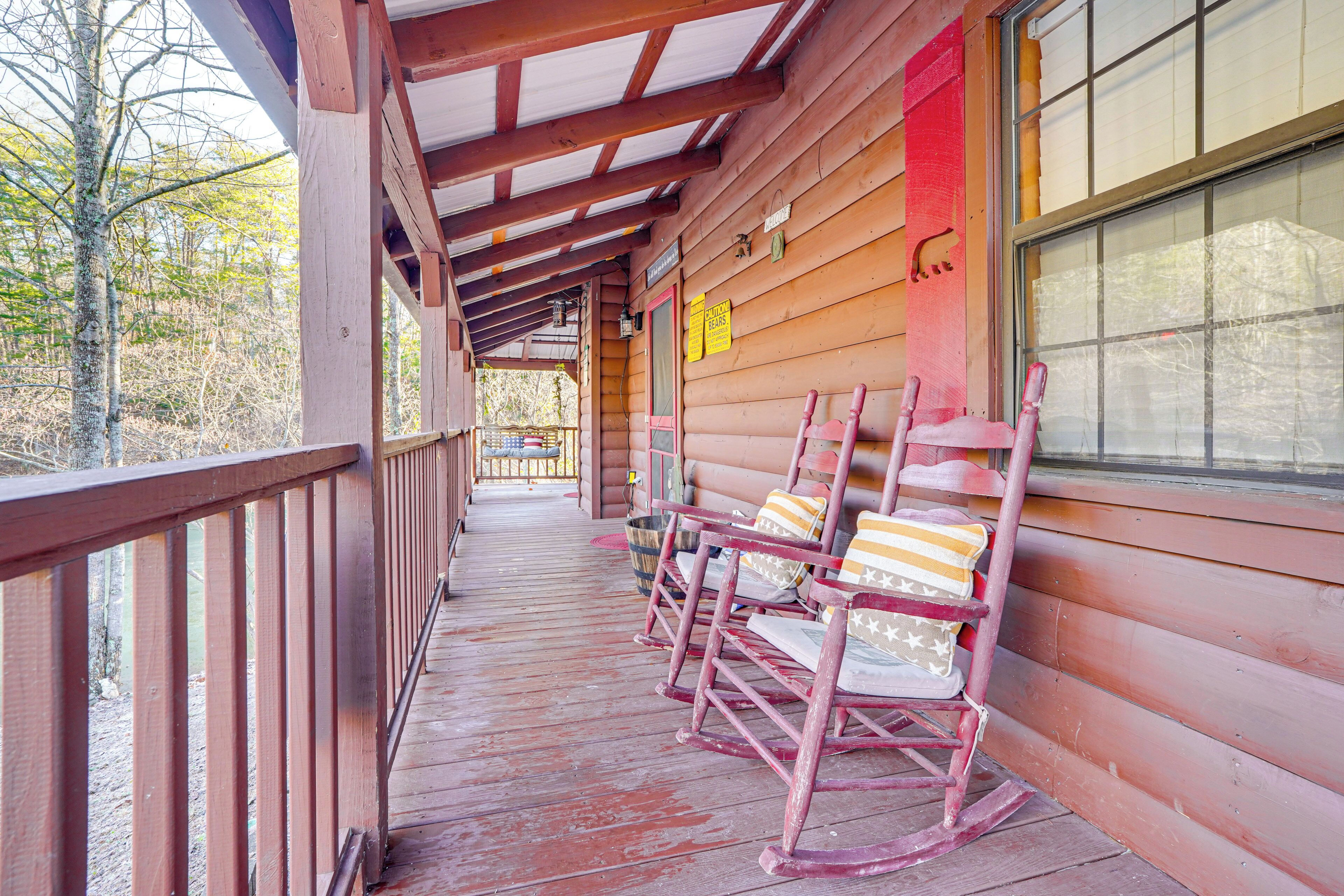 A wooden porch with rocking chairs and a covered walkway.