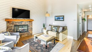 Una sala de estar con chimenea, un televisor de pantalla plana, un sofá y una mesa de centro.