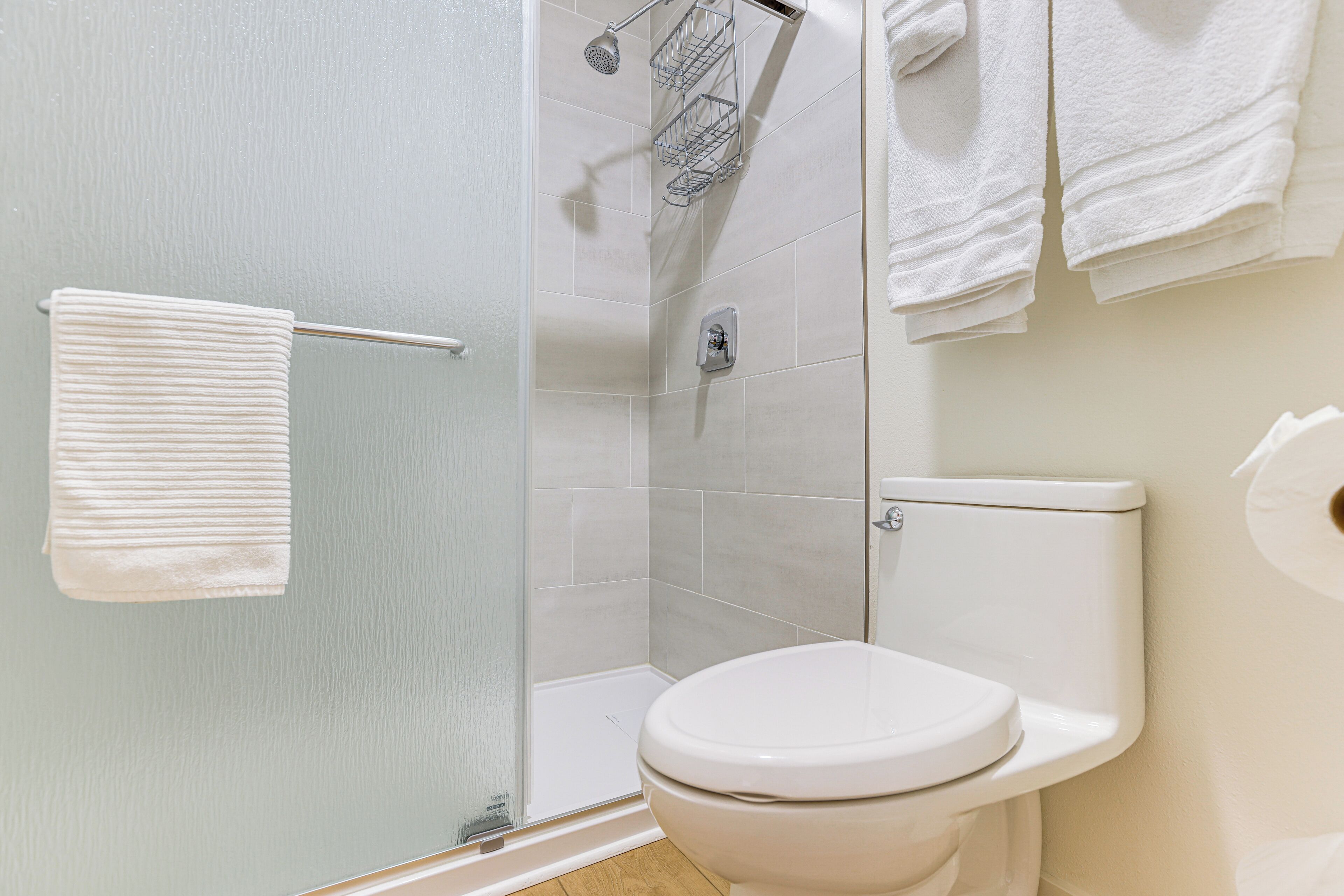 Un baño con inodoro, ducha y toallero.