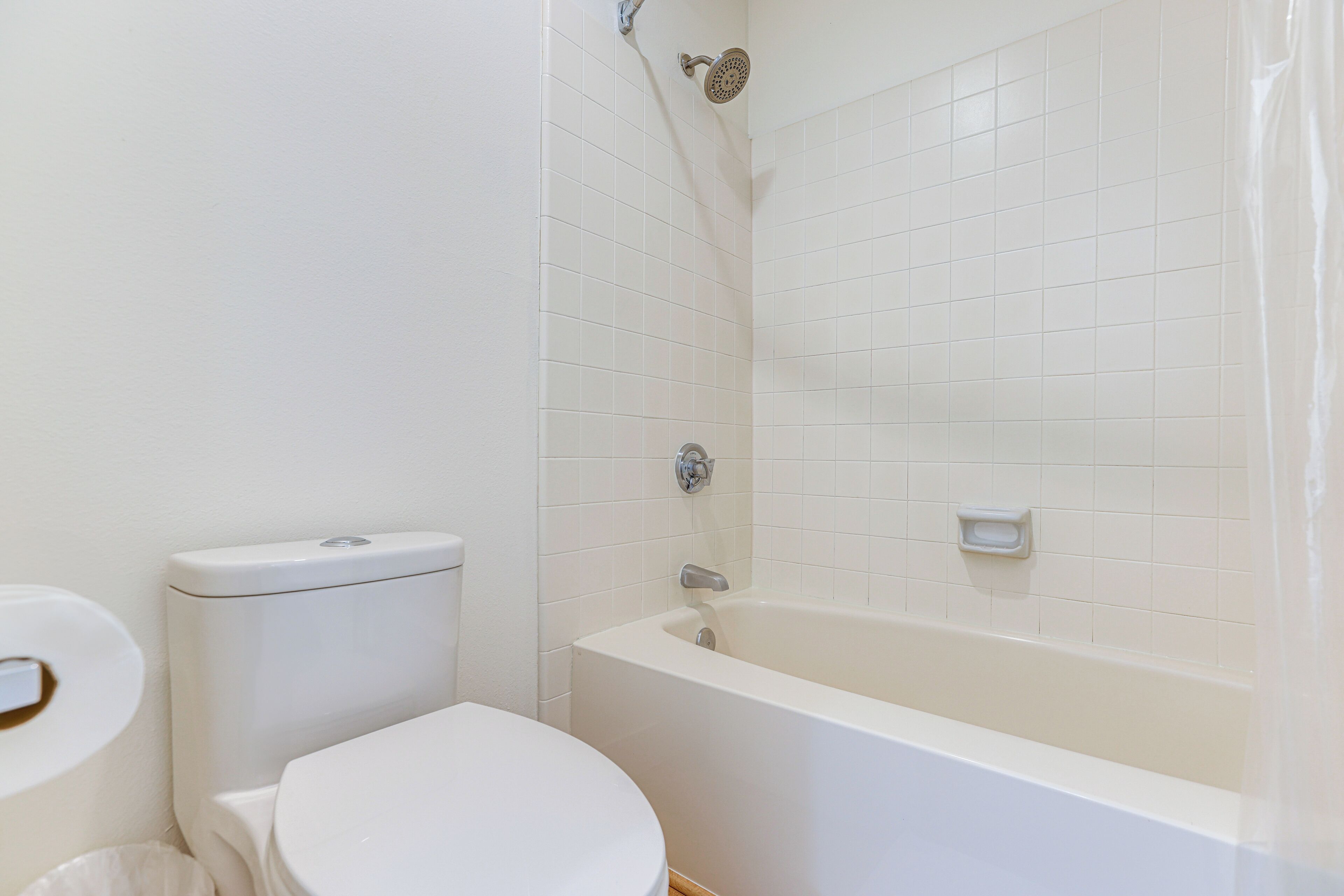 A bathroom with a toilet, a bathtub, and a shower.