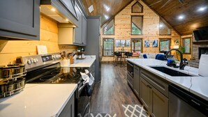 Een moderne keuken met een groot schiereiland, roestvrijstalen apparatuur en houten details.