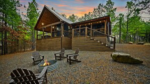 Een chalet met terras, buitenmeubels en een vuurkorf.