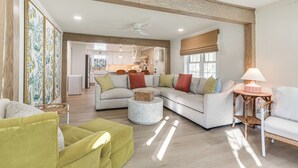 A spacious living room with a sectional sofa, a round coffee table, and a green armchair. - Walk to Lake Texoma: Kingston Retreat w/ Deck! (Kingston)