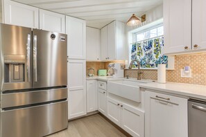 A modern kitchen with stainless steel appliances, white cabinetry, and a patterned backsplash. - Walk to Lake Texoma: Kingston Retreat w/ Deck! (Kingston)