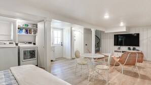 A modern apartment with a kitchen, dining area, and living space. It includes a washing machine, a dining table with chairs, and a TV. - Walk to Lake Texoma: Kingston Retreat w/ Deck! (Kingston)