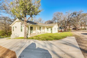 A single-story house with a front porch, a driveway, and a lawn.