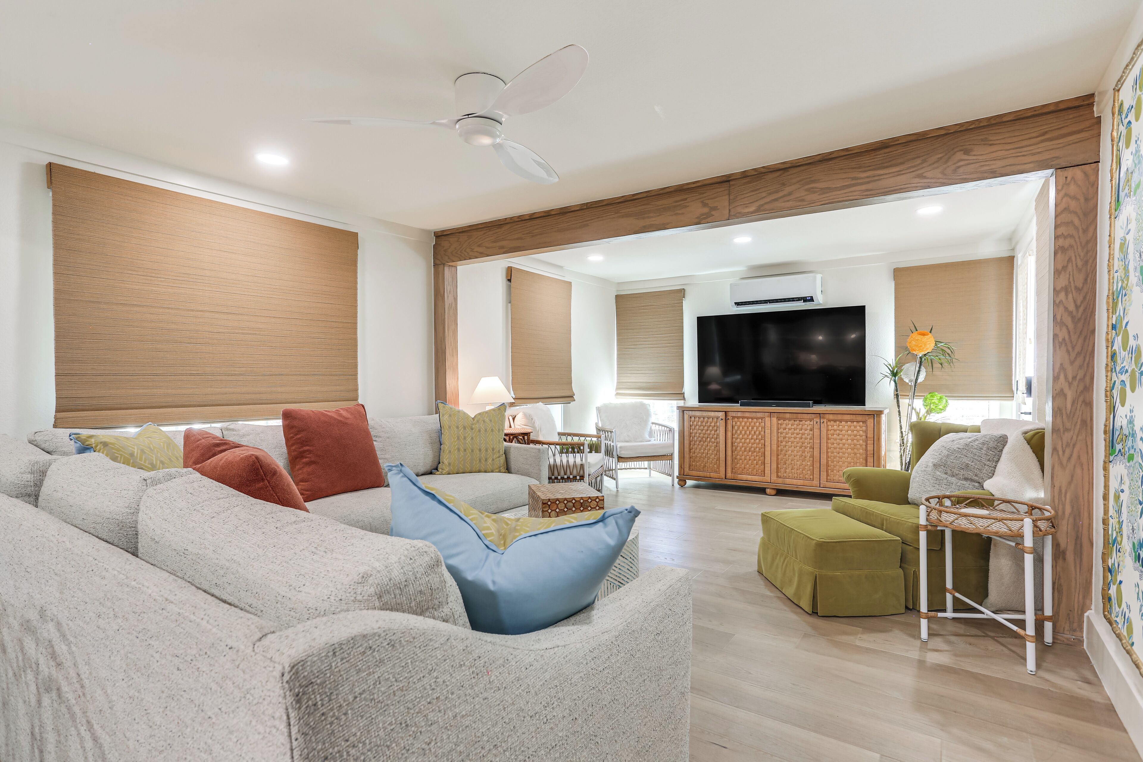 A modern living room with a sofa, ottoman, and a television.