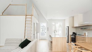 Una cocina moderna con armarios de madera, una isla central y taburetes de bar.