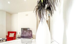 A modern living room with a marble table, a large white vase, and two chairs. - London 2-bed Apartment in Herbert Road (London)