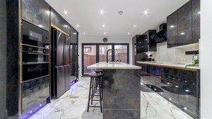 Una cocina moderna con una isla central, electrodomésticos integrados y vistas al exterior.