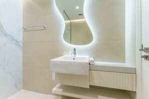 A modern bathroom with a white sink, mirror, and towel rack. - Renovated Unit w/ Skyscraper Views Close to Beach, Elite Residence,Dubai Marina (Dubai)