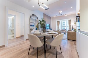 A modern dining area with a round table, four chairs, and a decorative centerpiece. - Renovated Unit w/ Skyscraper Views Close to Beach, Elite Residence,Dubai Marina (Dubai)
