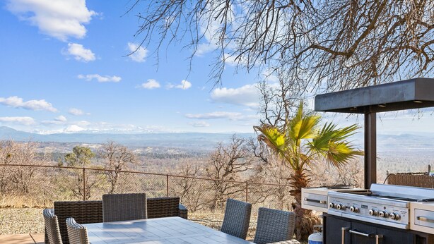 An outdoor dining area with wicker chairs and a table, overlooking a mountainous landscape. - Stunning Mountain Retreat With Unmatched Views 5 Bedroom Estate (Oak Run)