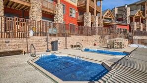 A hotel with outdoor pools, stone pillars, and wooden balconies. - 5959 Hidden River Lodge 2 Bedroom Condo (Keystone)