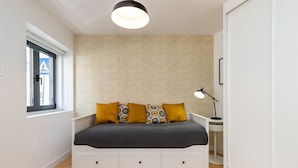 A bedroom with a bed, a desk, a lamp, and a window. - Belem Design Studio 2 by Homing (Lisbon)