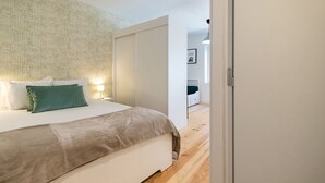 A modern bedroom with a large bed, a bedside table, and a wardrobe. - Belem Design Studio 1 by Homing (Lisbon)