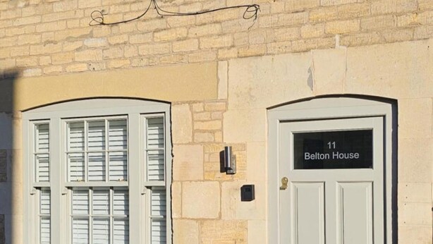 A building with two white doors, one labeled "Belton House" and the other with no visible label. - Stylish 2-bed House in Stamford Town Centre (Stamford)