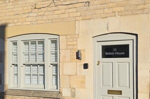 Un edificio con dos puertas blancas, una con el rótulo "Belton House" y la otra sin etiqueta visible.
