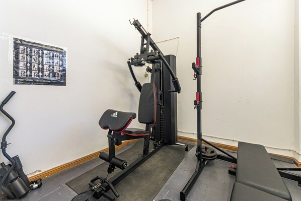 A gym with a bench, weight machine, and a poster on the wall. - 2 Bed-sleeps 4-vilamoura Beach-pool-spa-balcony (Loulé)
